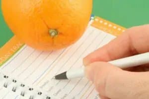 Femeie care scrie într-un jurnal al emoțiilor